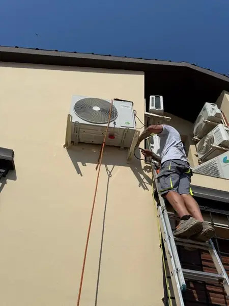 Técnico en escalera instalando HeatGun exterior — Instalaciones Tomás